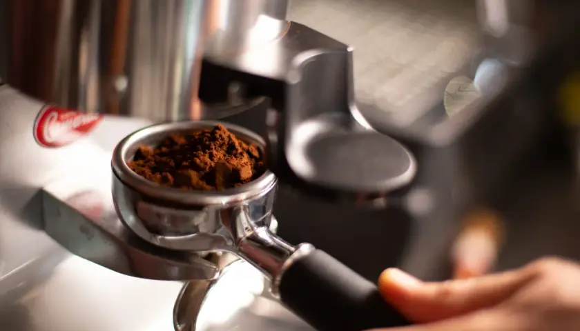 Portafiltro con macinatura caffè fine, pronto per l'estrazione. Regolare la macinatura caffè come fare per un espresso perfetto.