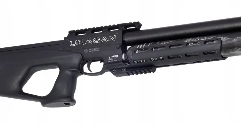 Czarny pistolet pneumatyczny z napisem "URAGAN". Posiada karbowany chwyt i lufę z włókna węglowego.