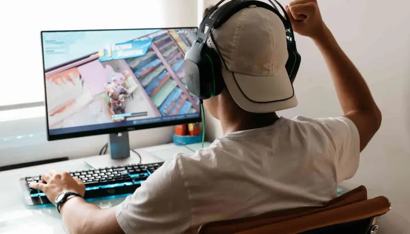 Junge spielt Videospiel, jubelt über Sieg. Er fragt sich, was VSync ist, um Ruckeln zu vermeiden.