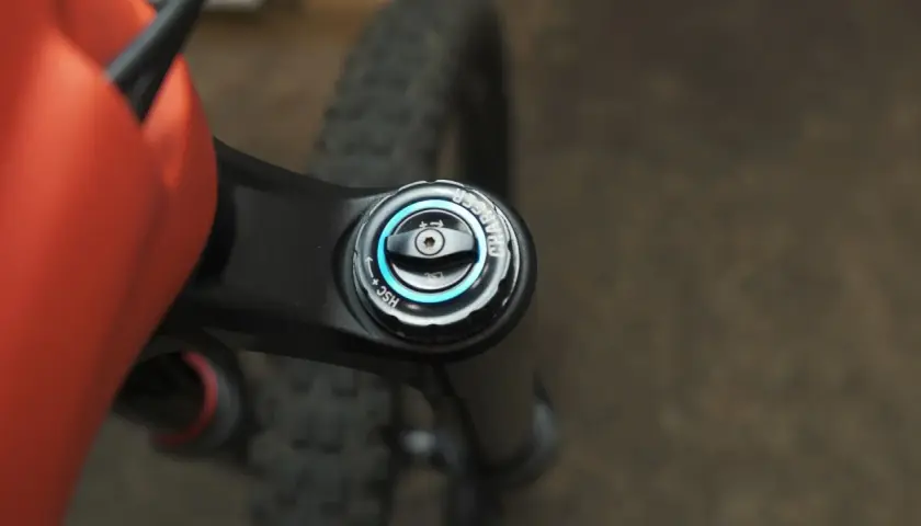 Close-up of an orange MTB frame and black suspension fork with a "Charger" damper adjustment knob, part of the mtb suspension setup.