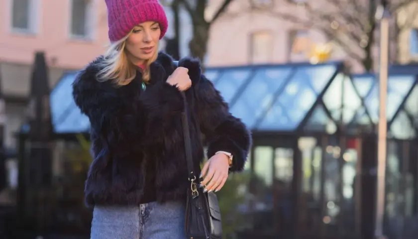 Krótkie futerko w stylizacji z jeansami i różową czapką. Oto inspiracja, jak nosić krótkie futerko tej zimy.