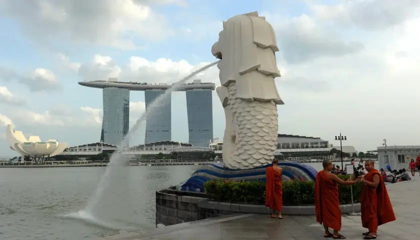 Mnisi w pomarańczowych szatach przy Merlionie, symbolu Singapuru, gdzie religia jest ważną częścią kultury.