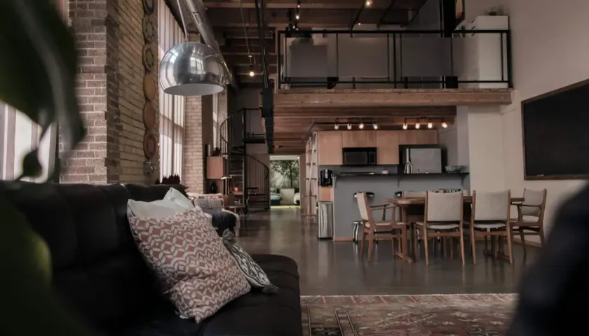 Stilvolle Einrichtung einer Maisonette-Wohnung mit industriellem Charme: Ledersofa, offene Küche, Essbereich und Galerie.