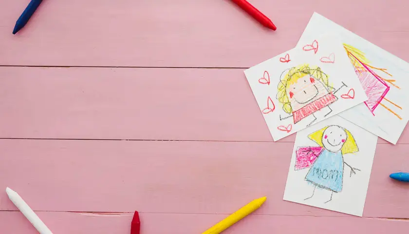 Dziecięce rysunki i kredki na różowym tle. Może to być ilustracja do sprawy o pozew o alimenty na dwoje dzieci.
