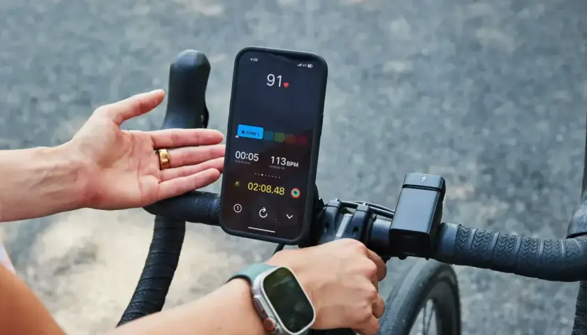 Rowerzysta monitoruje swój puls podczas treningu. Na ekranie telefonu widoczny jest puls 91 BPM, wskazujący na aktywność sportowca.