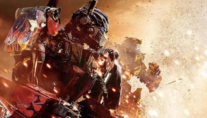 Optimus Prime i Bumblebee w akcji. W tle eksplozje i pył. Widać szczegółowe transformers części.