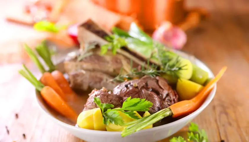 Un plat réconfortant de pot-au-feu, avec du bœuf tendre, des carottes, des pommes de terre et des poireaux, garni de persil frais.