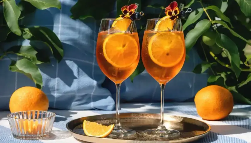 Dwa Aperol Spritz z pomarańczą i kwiatkiem. Idealne na lato, łatwo je zrobić!