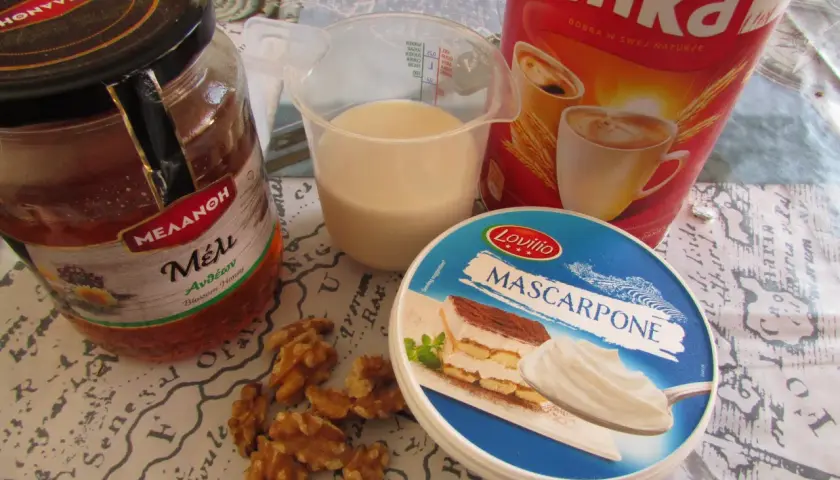Składniki na kawę Inka z mlekiem: słoik miodu, kubek mleka, opakowanie serka mascarpone, orzechy włoskie i puszka kawy Inka.