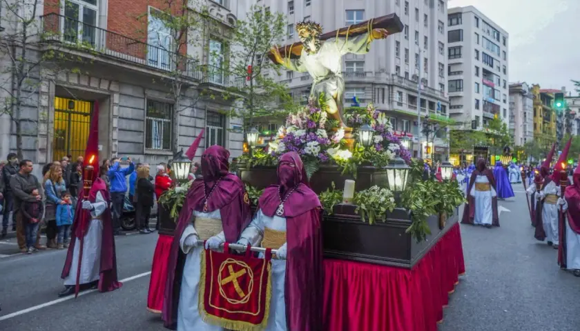 Procesiones Semana Santa Santander: figuras religiosas y nazarenos desfilan por la calle.