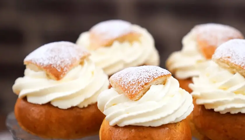 Fem fluffiga semlor med rikligt vispad grädde och pudrat florsocker. Perfekt för att baka egna semlor till fikat.