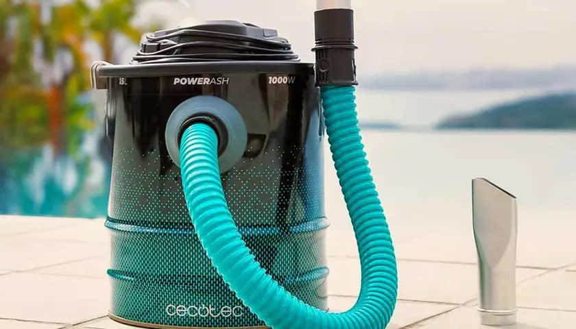 Aspirateur à cendres avec tuyau bleu et embout argenté, près d'une piscine.