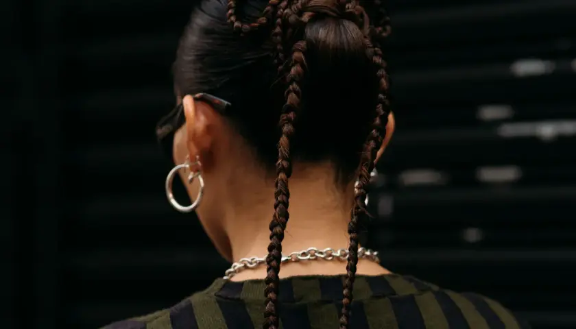 Peinados para conciertos: trenzas recogidas en forma de moño con dos coletas largas.