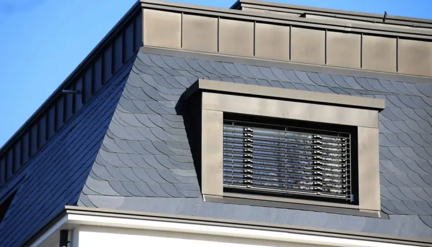 Schieferdeckung mit Fischschuppenmuster, ein Fenster mit Jalousien und ein Metalldach. Verschiedene verlegemuster schiefer deckungsarten.
