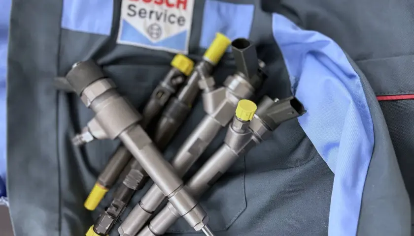 Wtryskiwacze diesla na tle logo Bosch Service. To gwarancja, że korekta wtrysku na plus jest w dobrych rękach.