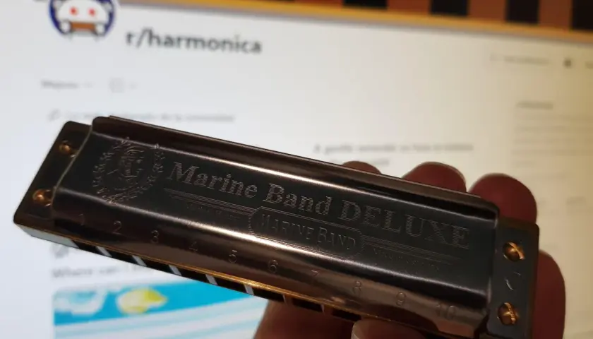 Harmonijka Marine Band DELUXE, z wygrawerowanymi nutami i numerami, gotowa do zagrania melodii.