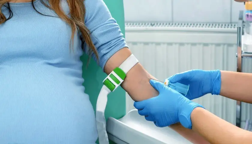 Gravid kvinna får blodprov taget, en del av kub test vecka.