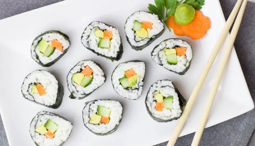 Talerz sushi z awokado, ogórkiem i marchewką. Czy sushi jest kaloryczne? Zależy od składników, ale te warzywne rolki wyglądają lekko!