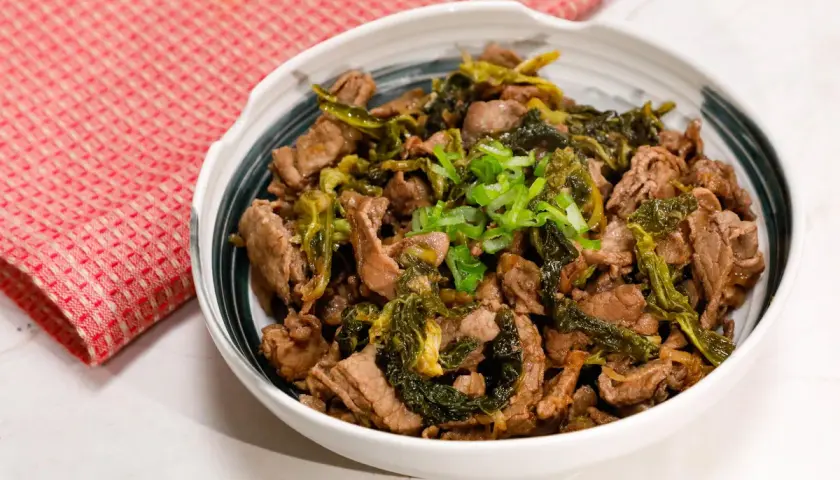 Straccetti di manzo saltati con verdure verdi e guarniti con cipollotto fresco. Un piatto saporito e invitante.