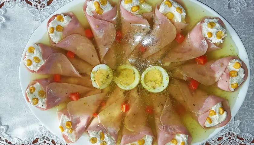 Roladki z szynki z serkiem almette i chrzanem, ozdobione kukurydzą, papryką i jajkiem na twardo, w galarecie.