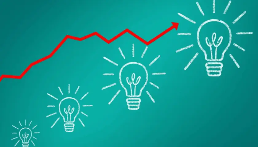 Gráfico de línea roja ascendente sobre bombillas de luz, simbolizando el crecimiento de **herramientas inteligentes** y la innovación.