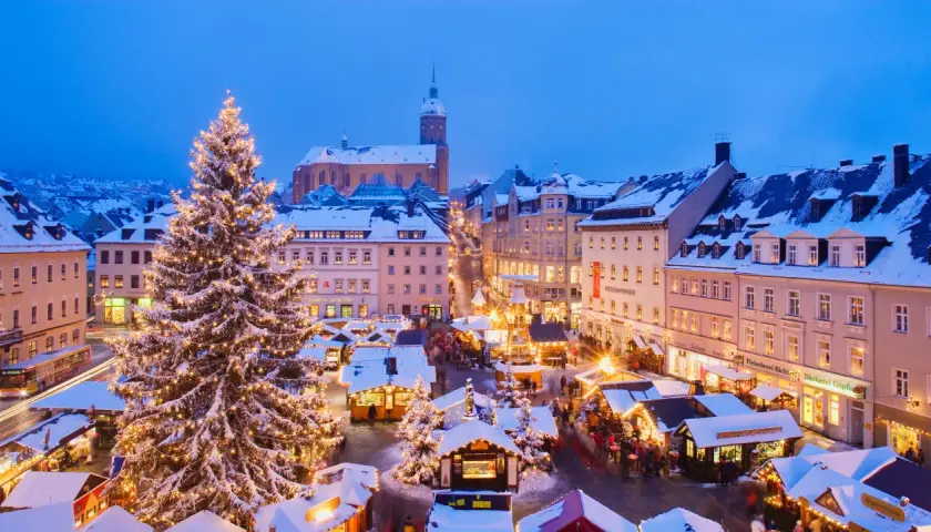 Beleuchteter Weihnachtsbaum und Buden auf dem Marktplatz. Ein festlicher Anblick, der an den besten Weihnachtsmarkt Deutschlands erinnert.