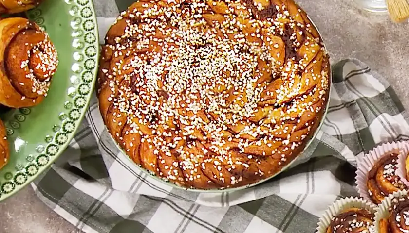 En stor kanelbulle och flera mindre bullar på bakpulver, redo att avnjutas.