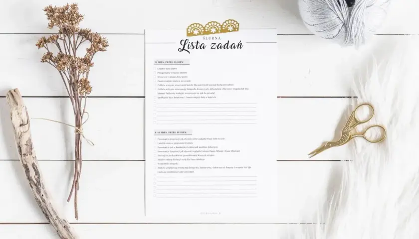 Lista zadań do zrobienia przed ślubem, z zaznaczonymi punktami. Obok leży gałązka suszonych kwiatów i złote nożyczki.