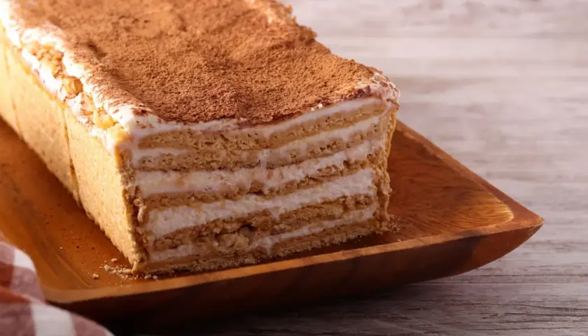 Pyszne, tanie ciasto bez pieczenia z herbatnikami i kremem, posypane kakao. Idealne na szybki deser.