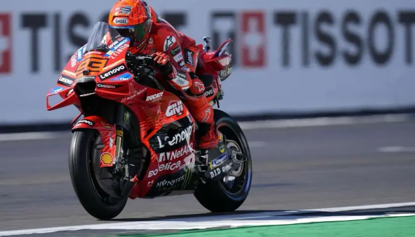 Piloto de Ducati en carrera, con su traje rojo y casco naranja. El número 23 es visible. Mar Márquez compite en la pista.