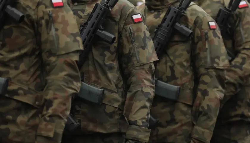 Żołnierze w mundurach moro, z karabinami, gotowi do służby. Każdy z nich, nawet najniższy stopień w wojsku, stanowi ważną część sił zbrojnych.