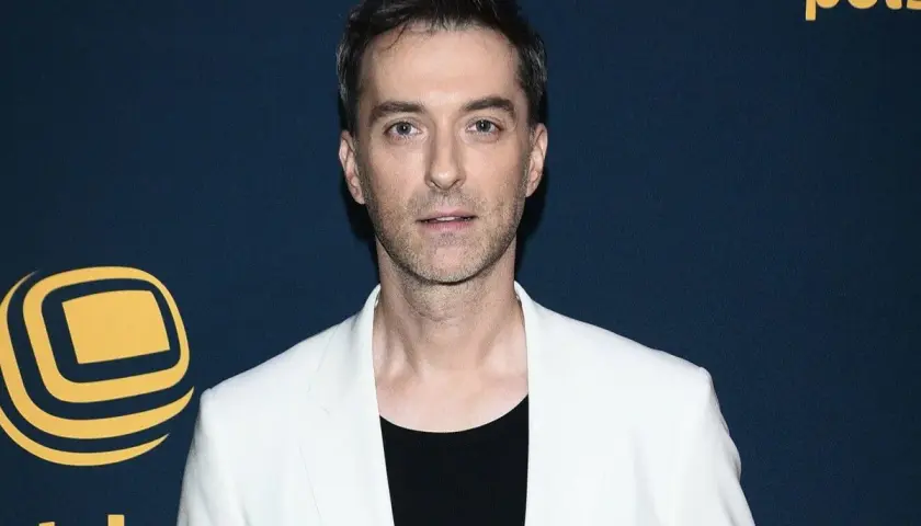 Filip Bobek w białej marynarce i czarnej koszulce, prezentuje się elegancko. Czyżby szykował się na randkę z żoną?