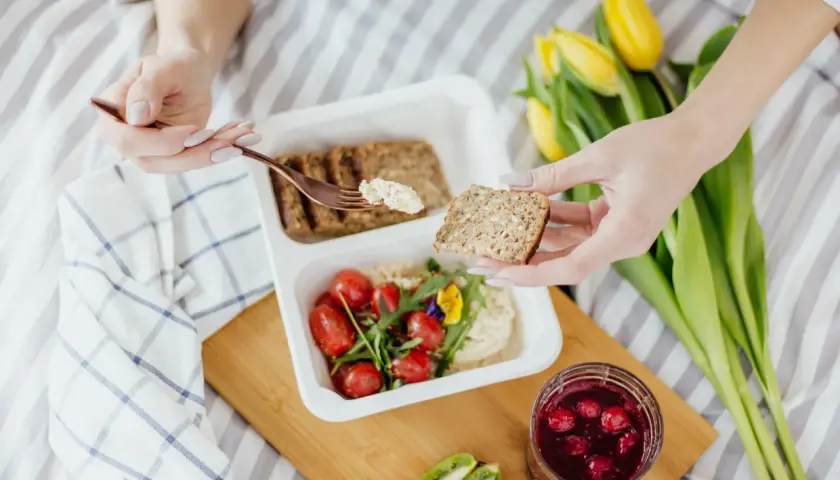 Zdrowy posiłek: pełnoziarniste pieczywo, hummus, pomidorki i owoce leśne. Idealne, by dowiedzieć się, co jeść na zaparcia.
