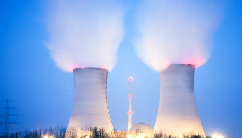 Dwie chłodnie kominowe elektrowni atomowej w Polsce wydzielają parę. W tle widać kopułę reaktora i wieżę.
