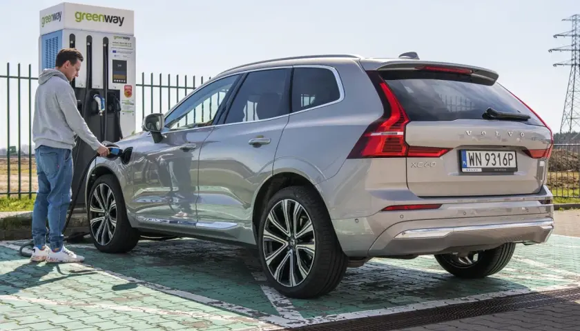 Mężczyzna ładuje Volvo XC60, nowoczesną turbo hybrydę, na stacji Greenway.