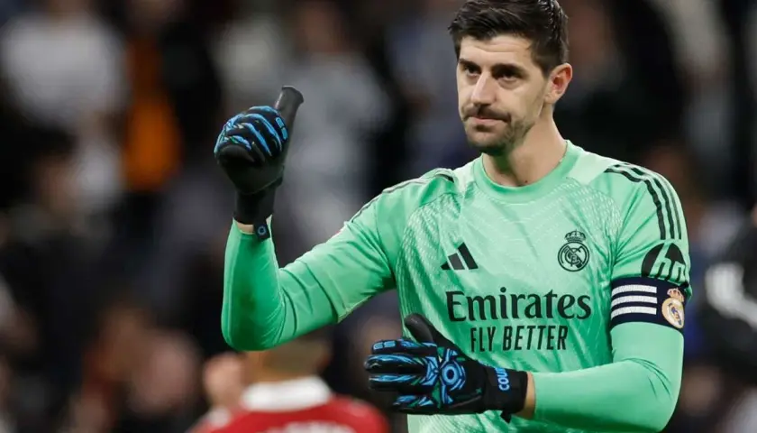 Thibaut Courtois, jeden z kapitanów Realu Madryt, w zielonej koszulce bramkarskiej, pokazuje kciuk w górę.