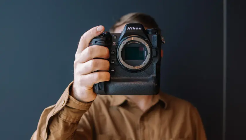 Osoba trzyma aparat Nikon Z9, zasłaniając twarz. Trwa test tego profesjonalnego sprzętu.