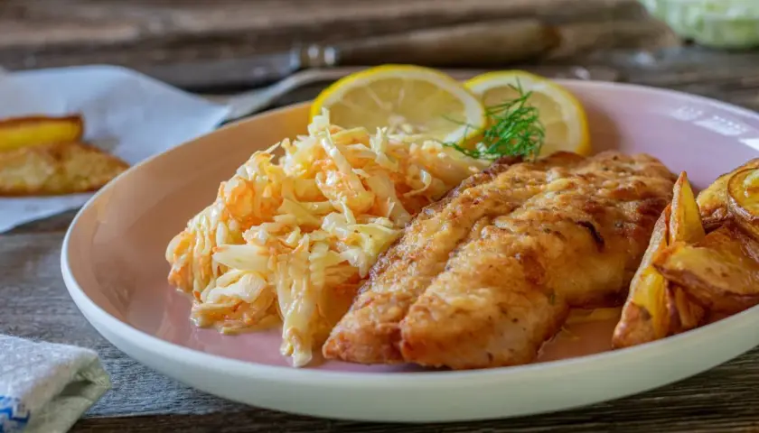 Chrupiący filet rybny z ziemniakami i świeżą surówką do ryby.