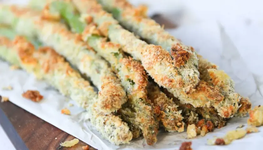 Espárragos verdes crujientes, empanizados y horneados, listos para disfrutar como aperitivo saludable.