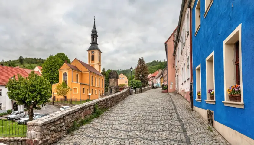 Kolorowy rynek w miasteczku, z pomarańczową świątynią i niebieskim budynkiem.