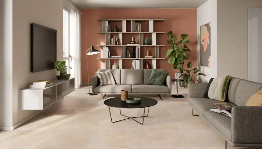Soggiorno moderno con divani grigi, libreria e un elegante pavimento effetto cemento abbinamento perfetto con l'arredo.