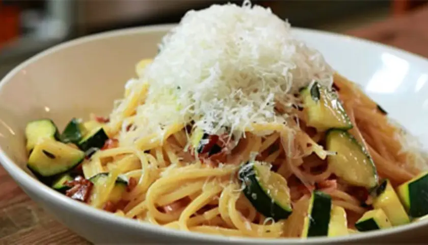 Spaghetti mit Zucchini und Speck, gekrönt mit frisch geriebenem Parmesan. Eine köstliche Zucchini Carbonara.