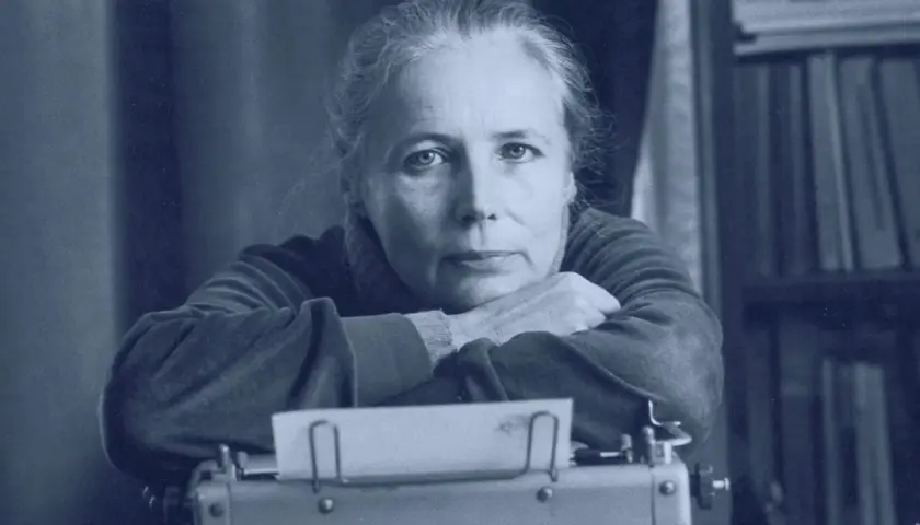 Agnieszka Osiecka przy maszynie do pisania, w tle regał z książkami. Jej teksty wciąż inspirują.