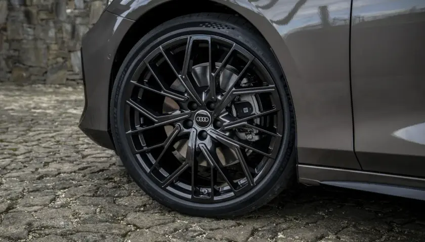 Błyszczące, czarne felgi Audi z homologacją opon Michelin Pilot Sport 5 na kamiennej nawierzchni.