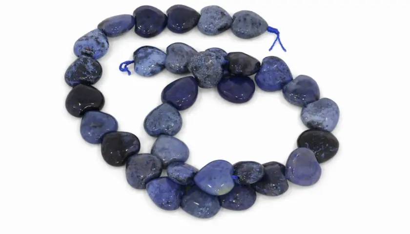 Herzförmige Perlen aus blauem Dumortierit, auf einer Schnur aufgereiht, mit dunklen und hellen Mustern.