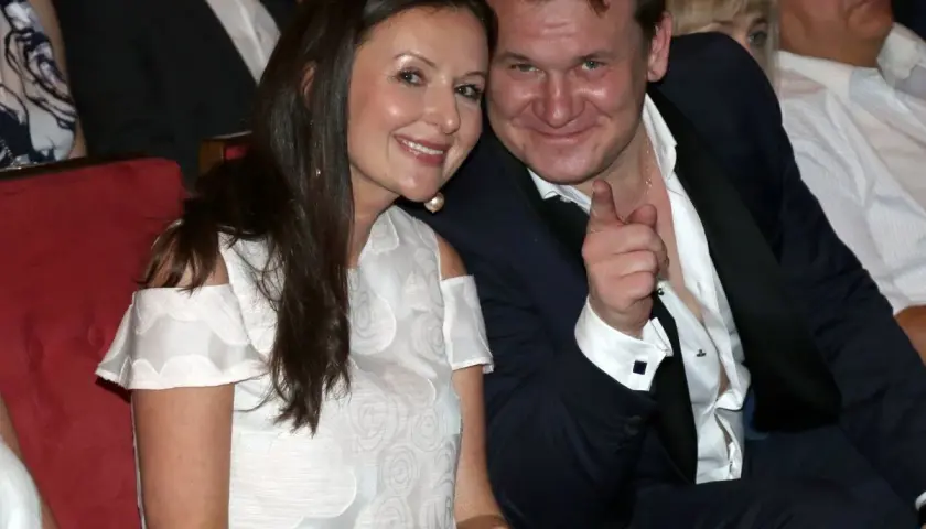 Dominik Tarczyński z żoną i dziećmi, uśmiechnięci, w eleganckich strojach, podczas wydarzenia.