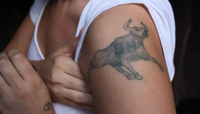 Mały tatuaż byk na ramieniu, symbol siły i odwagi.
