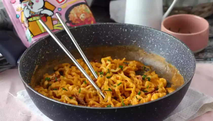 Pikantny buldak carbonara w kremowym sosie, gotowy do jedzenia.