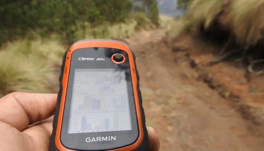Ręka trzyma GPS Garmin Etrex 20x, idealny do poszukiwań w terenie. To właśnie dzięki takim urządzeniom odkrywasz, geocaching co to jest i jak działa.
