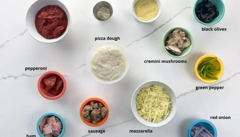 Składniki na pizzę: ciasto, sos, ser, pieczarki, salami, szynka, kiełbasa, oliwki, papryka, cebula. Pieczarki do pizzy są już pokrojone.
